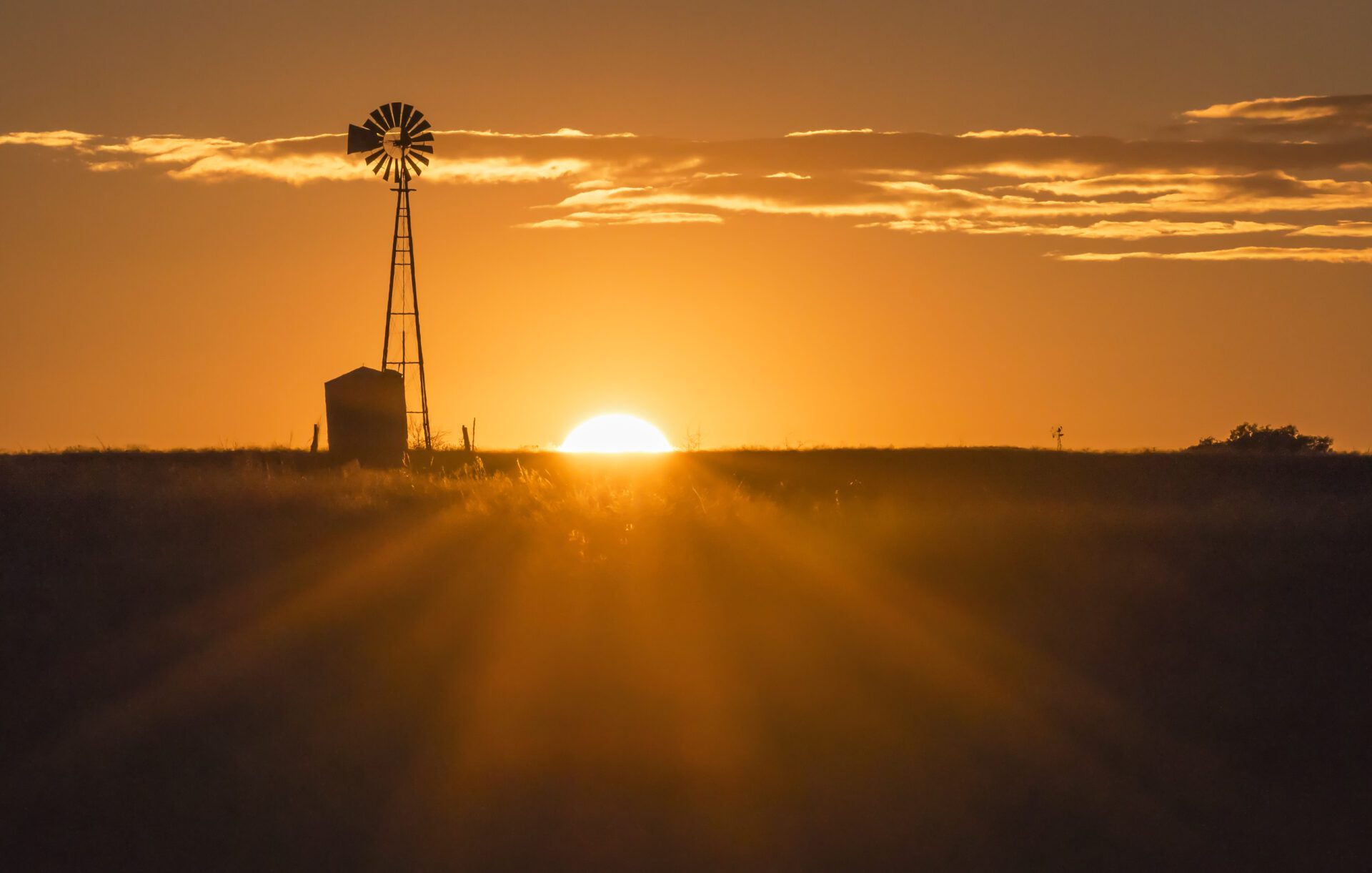 The Sun Sets Near A Windmill In The Texas Hill